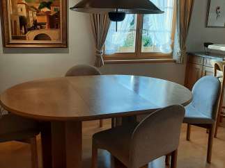 This charming dining area features a round wooden table, perfect for intimate gatherings.