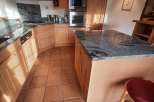 This charming kitchen boasts a warm and inviting atmosphere with its natural wood cabinetry and terracotta tile flooring.