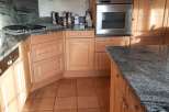 This kitchen boasts beautiful wooden cabinetry and a sleek granite countertop, creating a warm and inviting atmosphere.