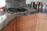 This kitchen boasts a stylish granite countertop and backsplash, creating a sleek and modern aesthetic.