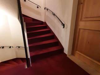 This elegant staircase features a rich red carpet, creating a warm and inviting atmosphere.