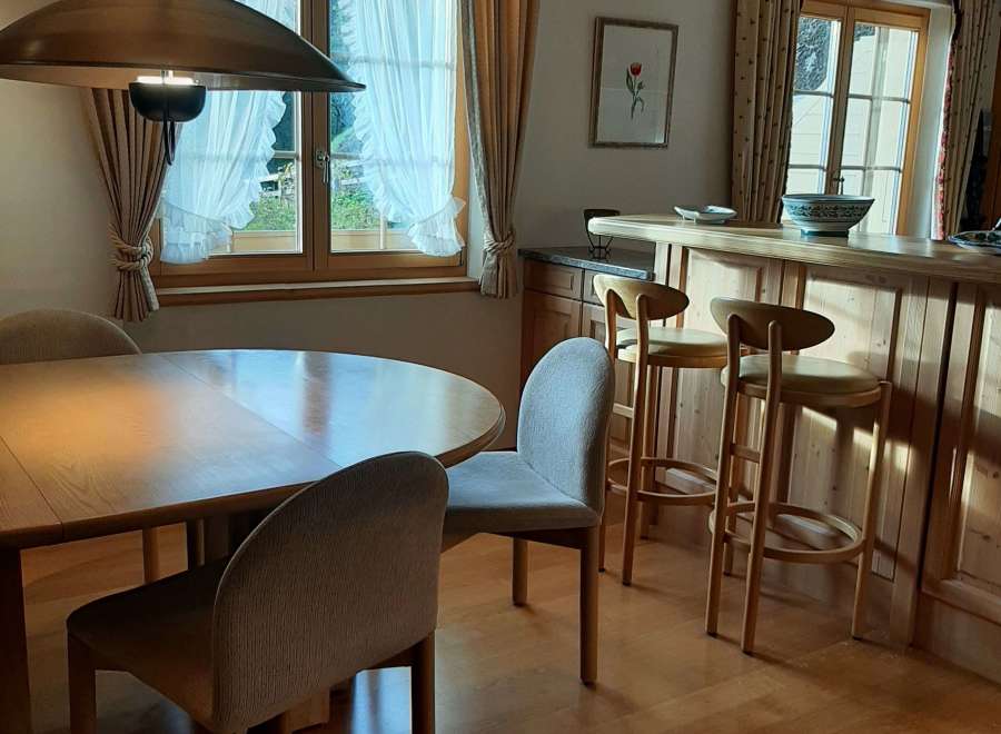 This charming property features a cozy dining area with a round wooden table and comfortable chairs, perfect for intimate meals.