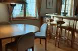 This charming property features a cozy dining area with a round wooden table and comfortable chairs, perfect for intimate meals.