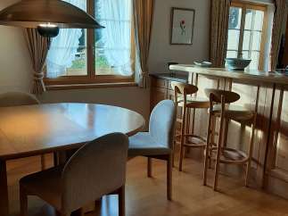 This charming property features a cozy dining area with a round wooden table and comfortable chairs, perfect for intimate meals.