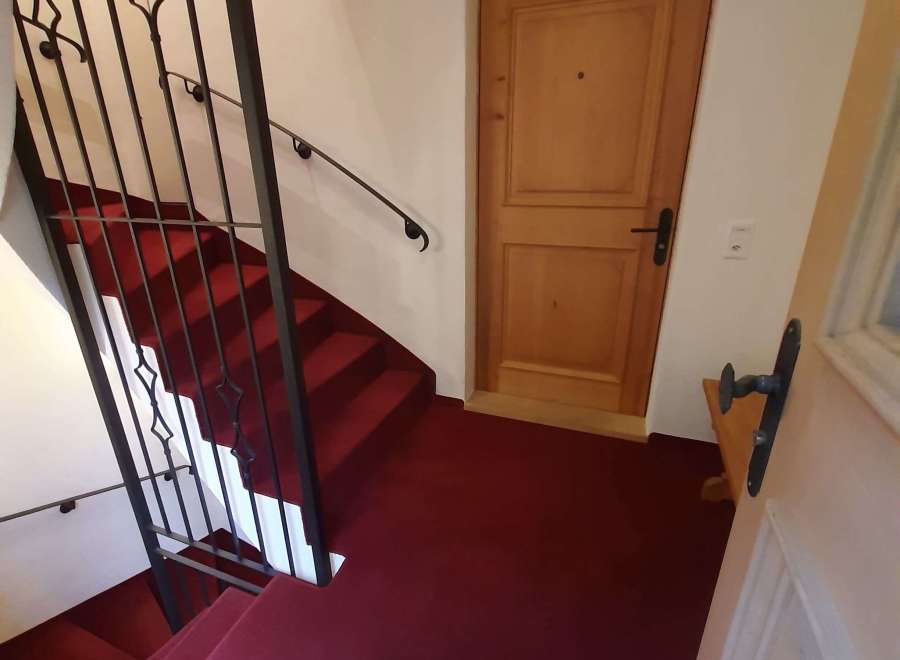 Discover a charming property featuring a beautifully designed staircase with a striking red carpet.