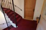 Discover a charming property featuring a beautifully designed staircase with a striking red carpet.