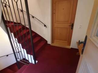 Discover a charming property featuring a beautifully designed staircase with a striking red carpet.