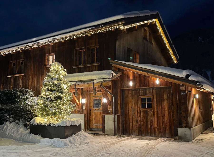 Experience the charm of a cozy wooden chalet nestled in a snowy landscape.
