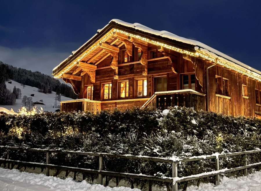 Experience the charm of a cozy wooden chalet nestled in a snowy landscape.