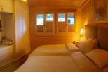 Cozy bedroom with wooden walls and a comfortable bed.