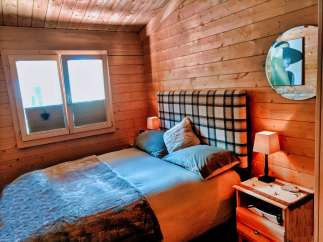 Cozy cabin bedroom with wooden walls and a comfortable bed.