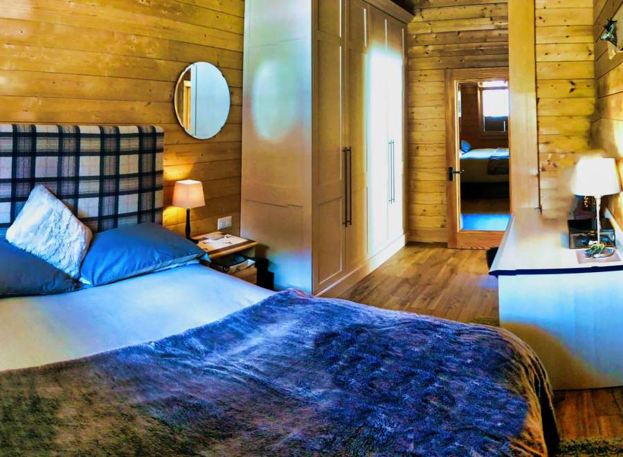 Cozy bedroom with wooden walls and a comfortable bed.