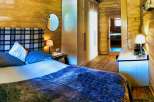 Cozy bedroom with wooden walls and a comfortable bed.