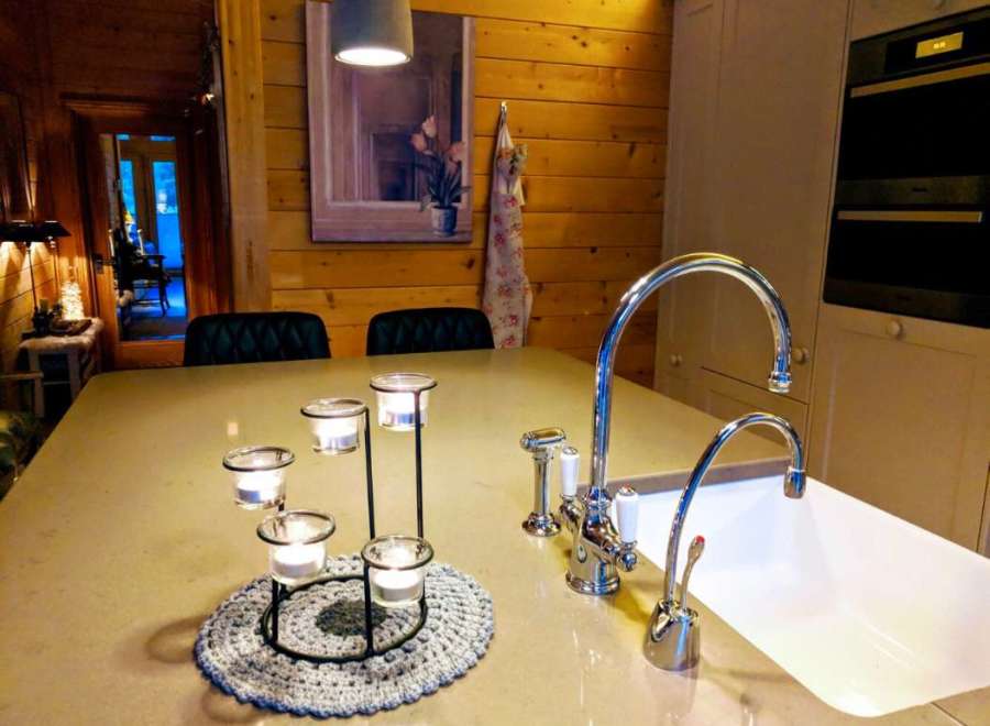 This cozy kitchen features a beautiful wooden wall and a modern sink.