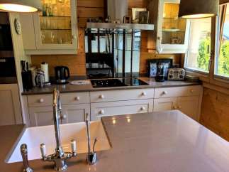 This stunning kitchen boasts a modern design with a touch of rustic charm, featuring sleek countertops and elegant cabinetry.