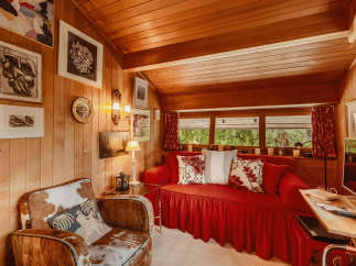Step into a cozy cabin retreat with warm wood paneling and a charming ambiance.