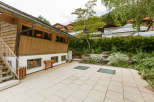Discover a charming property featuring a unique wooden facade and a welcoming outdoor patio.