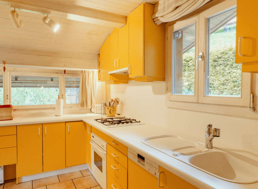 This charming kitchen boasts a vibrant yellow color scheme, creating a warm and inviting atmosphere.