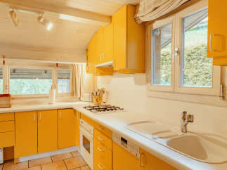 This charming kitchen boasts a vibrant yellow color scheme, creating a warm and inviting atmosphere.