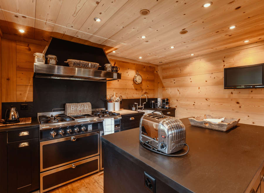 This stunning kitchen boasts a rustic charm with its warm wooden walls and ceiling.