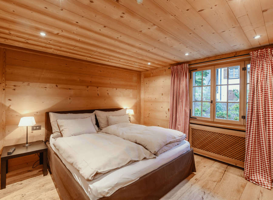 This cozy bedroom features a warm wooden interior, creating a rustic and inviting atmosphere.
