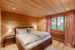 This cozy bedroom features a warm wooden interior, creating a rustic and inviting atmosphere.
