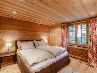 This cozy bedroom features a warm wooden interior, creating a rustic and inviting atmosphere.