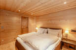 Experience the warmth of a cozy bedroom with wooden walls and ceiling.