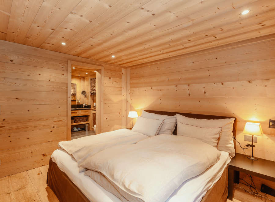Experience the warmth of a cozy bedroom with wooden walls and ceiling.