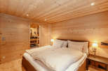 Experience the warmth of a cozy bedroom with wooden walls and ceiling.