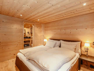 Experience the warmth of a cozy bedroom with wooden walls and ceiling.
