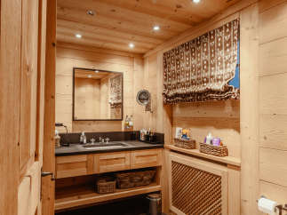 This cozy bathroom features beautiful wooden paneling throughout, creating a warm and inviting atmosphere.