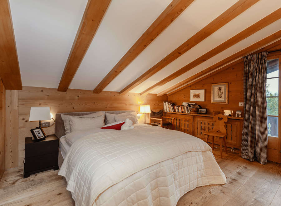 Experience the warmth of this cozy bedroom with its charming wooden accents and inviting ambiance.