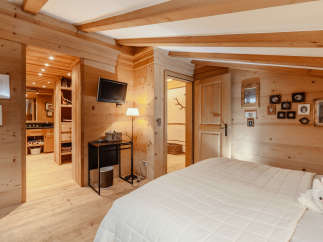Experience the warmth of this cozy bedroom, featuring stunning wooden accents throughout.