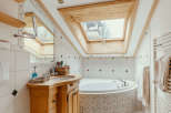 This charming bathroom features a unique skylight, allowing natural light to flood the space.