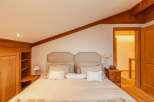 This cozy bedroom features a warm, inviting atmosphere with wooden accents and a comfortable bed.