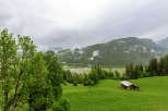 Discover the tranquility of this stunning landscape, featuring lush green fields and majestic mountains.