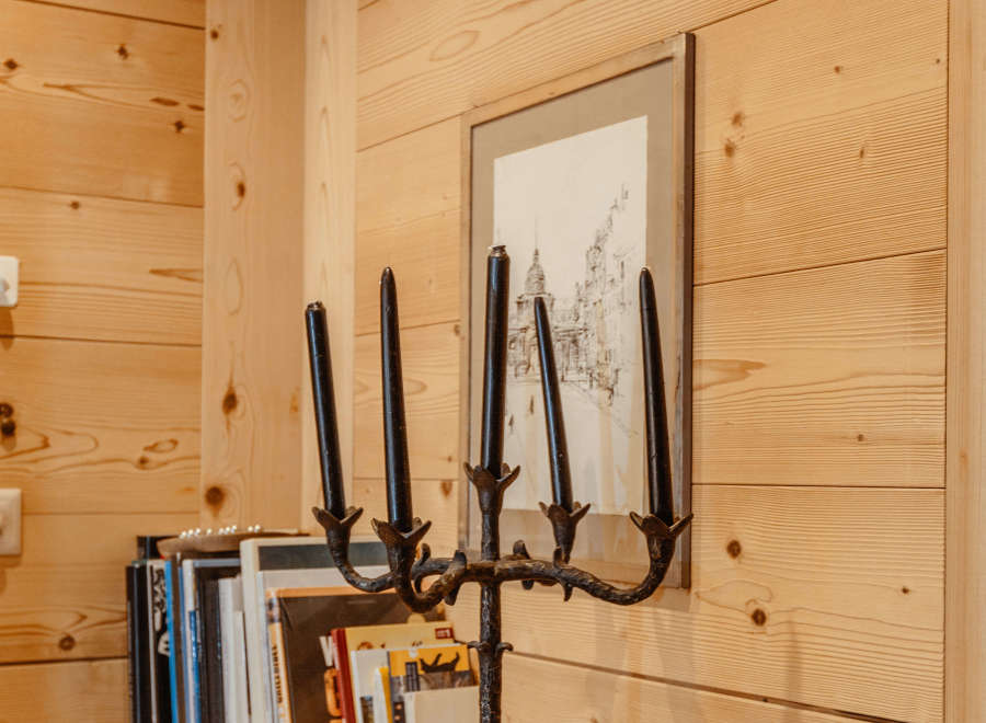 This cozy space features beautiful wooden walls and a rustic wooden shelf.