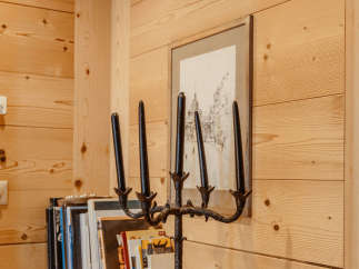This cozy space features beautiful wooden walls and a rustic wooden shelf.
