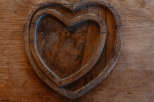 This image showcases a rustic wooden heart-shaped tray, perfect for adding a touch of warmth and charm to any space.