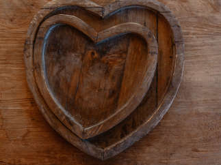 This image showcases a rustic wooden heart-shaped tray, perfect for adding a touch of warmth and charm to any space.