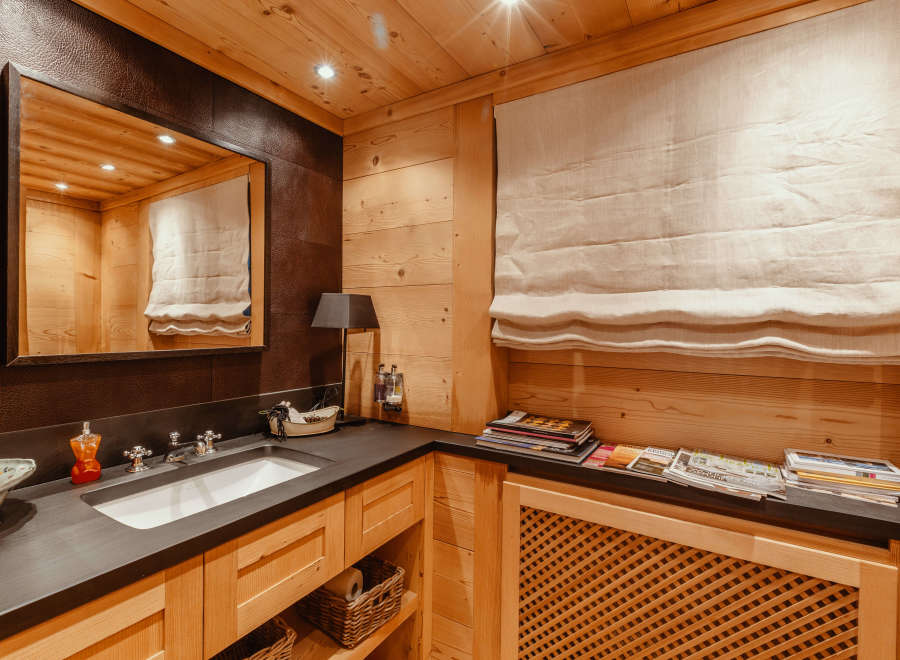 This luxurious bathroom features a warm, inviting ambiance with its wooden paneling and elegant design.