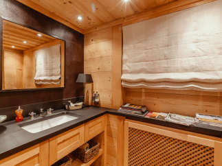 This luxurious bathroom features a warm, inviting ambiance with its wooden paneling and elegant design.
