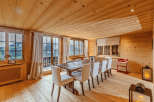 Experience the warmth of this inviting dining room, featuring a rustic wooden table and elegant white chairs.