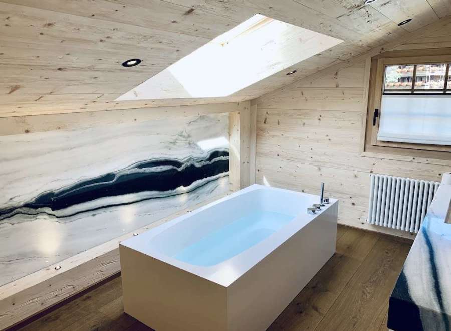 Experience luxury in this stunning bathroom with a unique marble accent wall.