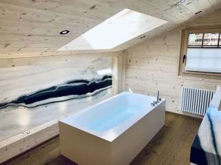 Experience luxury in this stunning bathroom with a unique marble accent wall.