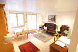 This charming living space features a cozy seating area with a tufted leather sofa and armchair, perfect for relaxation.