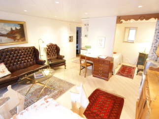 This charming living space features a classic Chesterfield sofa and a cozy armchair, perfect for relaxing.