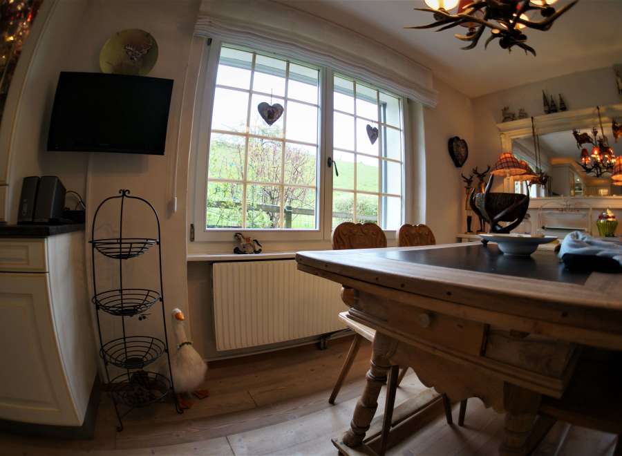 This charming dining room features a rustic wooden table, perfect for family gatherings.