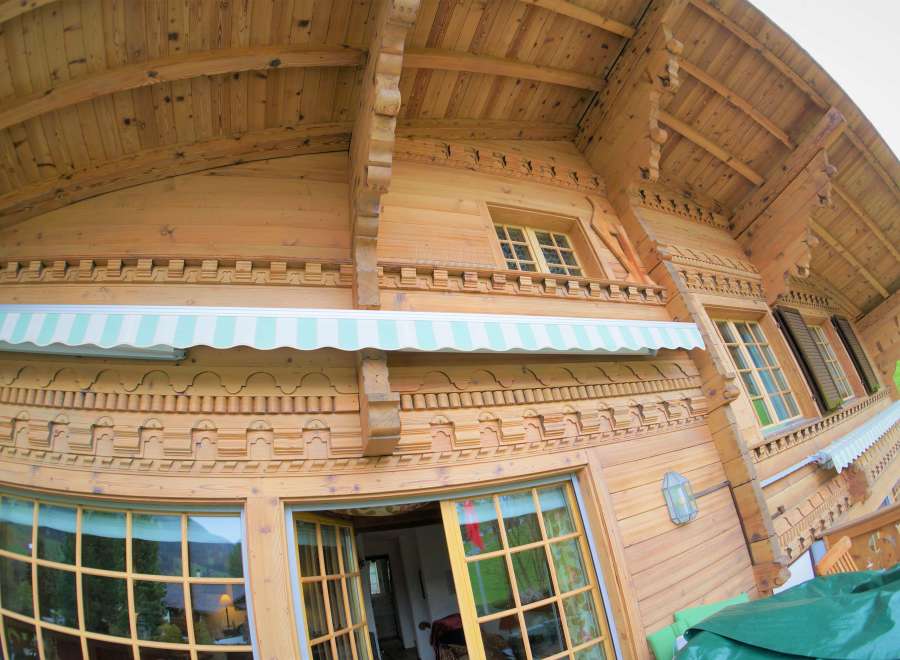 Discover the charm of this stunning wooden chalet, showcasing intricate carvings and a warm, inviting ambiance.